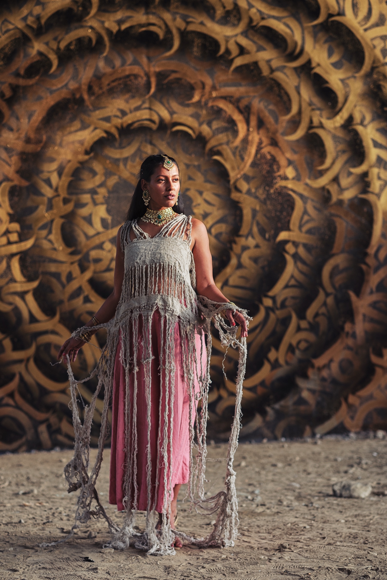 Kiranmai Uppuluri in Kraków displaying a handmade linen dress against a patterned wall